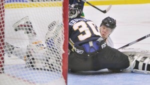 Austin's Christian Folin slides into Alexandria goalie Jameson Shortreed after scoring in the second period Saturday night at Riverside Arena.