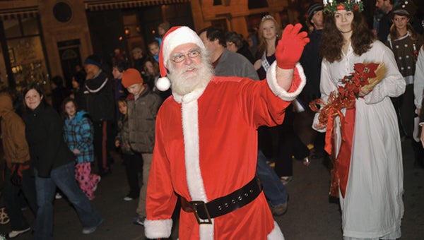 Santa Clause waves to the crowd as he marches down Main Street South for the lighting of the decorations during Christmas in the City last year. -- Herald file photo