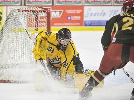 Austin's Nick Lehr jumps on a lose puck during the first period earlier this year against Minot at Riverside Arena.