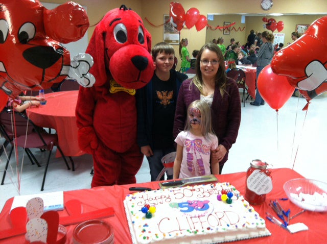 Clifford the Big Red Dog gathers by the cake with sweepstakes winner Heather Blume and her two children at a Sunday celebration at the YMCA in Austin for Clifford’s 50th anniversary. Heather was one of five people in the nation to win a Clifford-themed party with 50 of her friends and family as guests. -- Photo provided