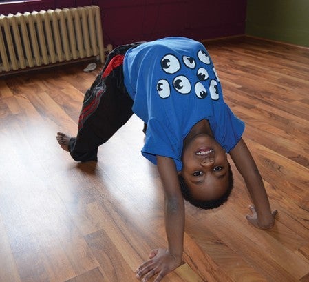 Isaiah Cabeen holds a bridge pose during a children's yoga class at the Yoga Studio of Austin Tuesday.