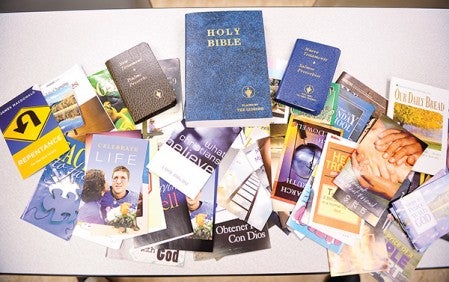 Bibles and pamphlets are spread out on the table in the Jail and Justice Center, items passed out by Bill Holder to inmates when he visits.