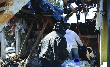 Volunteers pore through the remains of Judy and Ken Esplan's Blooming Prairie home Wednesday. The Esplans' home started on fire early Monday morning.
