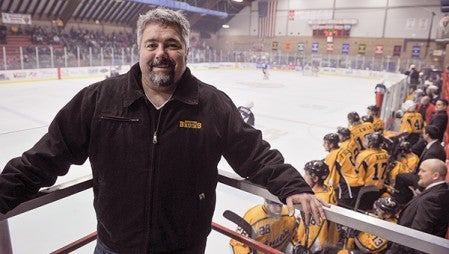 Craig Patrick, owner of the Austin Bruins stands near the Bruins bench during a January game against Coulee Region. In its third year the organization has grown and surged in the NAHL with an average fan draw of over 1,000 people and one of the top records in the NAHL.