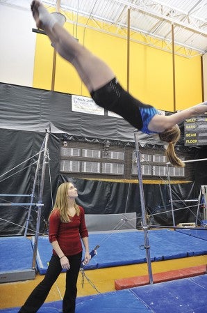 Amy Hejek watches her neice Abby Bickler practice on the uneven parallel bars at the YMCA. There has been a history with the family as Amy was a Minnesota State Champion on the floor in 2002 for Austin.