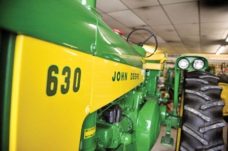 A restored John Deere 630 is one of several tractors sitting in Lee J. Sackett, Inc.'s showroom in Waltham.