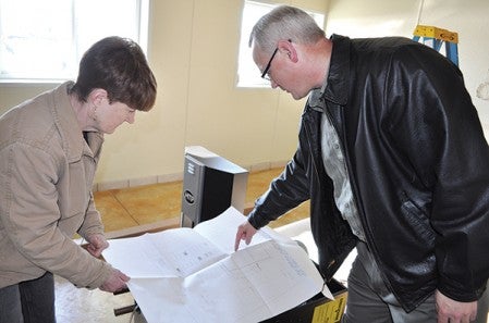 Mower County Humane Society volunteer Kelly Rush, left, looks over design plans with MCHS President Jay Lutz. Trey Mewes/trey.mewes@austindailyherald.com
