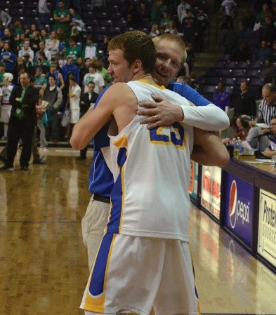 Hayfield head coach Chris Pack and Brady Kramer share a hug after the Vikings knocked off No. 3 ranked Maple River in the Section 2AA South title game in the Taylor Center in Mankato Monday. -- Rocky Hulne/sports@austindailyherald.com