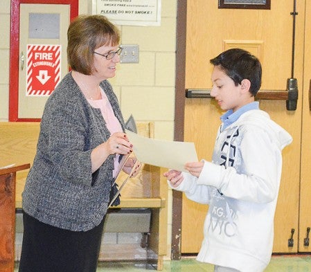 Pacelli sixth-grader Dylan Deveza accepts his recognition for good grades during the Honor Roll Brunch at St. Augustine's Church Tuesday morning.