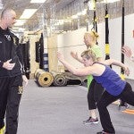 Impact Martial Arts & Fitness owner Troy Williams makes sure TRX class participants watch their form during a class last Thursday.