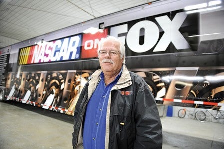 Steve Durst, owner of Featherlite Graphics east of Grand Meadow, stands in front of a Fox NASCAR broadcast trailer that the company is in the midst of wrapping, one of several big jobs the company undertakes.