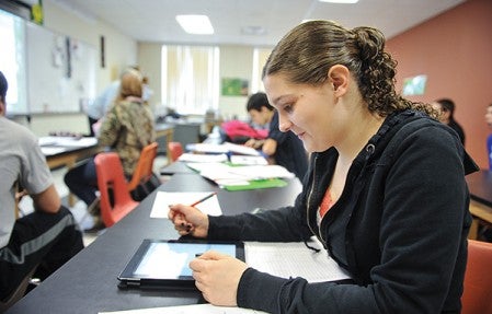 Lyle student Kim Krulish works on an iPad in a chemistry class. The school has embraced the use of technology like the iPad investing in 120 of the computers to date.