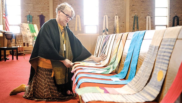 Aleta Christopherson arranges stoles for the Shower of Stoles exhibit at First Congregational Church. The exhibit, which supports the LGBT who are of faith, starts today and goes through May 15. -- Eric Johnson/photodesk@austindailyherald.com