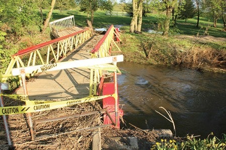 A bridge crossing the Rose Creek at Jellystone Campground lies in shambles Monday afternoon.