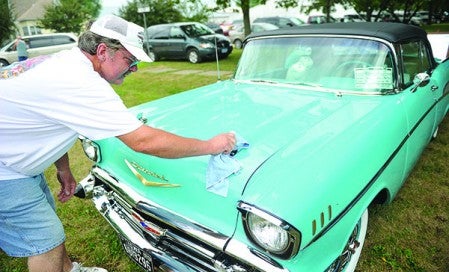 Bob Adams of Osage, Iowa polishes the hood of his '57 Chevy as cars begin rolling in for the 10th annual Car and Motorcycle Show last year at LeRoy Summerfest. Herald file photo