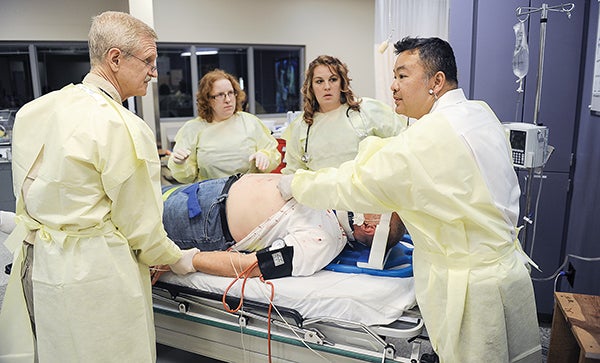 Volunteers attending the Minnesota Simulation Conference take part in a simulated gunshot wound in the simulation lab at Riverland Community College. Eric Johnson/photodesk@austindailyherald.com