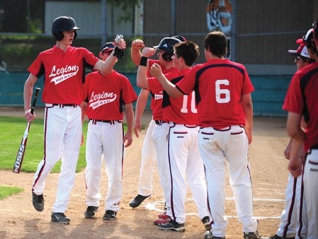 Dylan See-Rockers of the Albert Lea/Austin American Legion baseball team is congratulated by his teammates after scoring a run Monday against Winona at Hayek Field. -- Micah Bader/Albert Lea Tribune