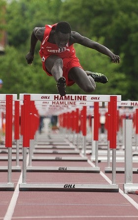 Austin's Omot Okello clears the final hurdle in his heat of the 110-hurdle preliminaries Friday in the Class AA Minnesota State Track and Field Meet at Hamline University in St. Paul. -- Eric Johnson/photodesk@austindailyherald.com