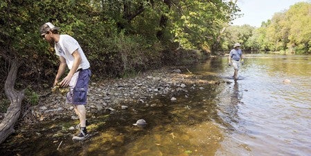 Nick Pedersen and Jeff Ollman comb the shore of the Cedar River south of Austin, looking for trash down a one-mile stretch of the river last September. Herald file photo