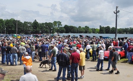 A large crowd gathers around the next car up for bid at the auction Saturday.