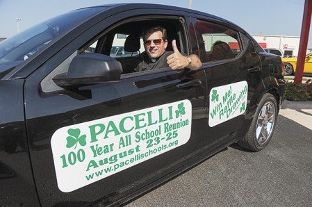 Father Jim Steffes gives a thumbs-up from the driver's seat of the 2013 Dodge Avenger, the top prize in Pacelli's All-School reunion in celebration of the school's 100 years.