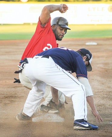 The Austin Greyhounds' Jeremy Williams slides safely into third ahead of the tag of Blue Sox third baseman DJ Taylor Friday night at Marcusen Park.