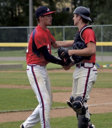 Austin pitcher Marcus Stoulil, left, is greeted by catcher Gabe Kasak in Marcusen Park Saturday. Stoulil pitched a three-hit shutout against Faribault. -- Rocky Hulne/sports@austindailyherald.com