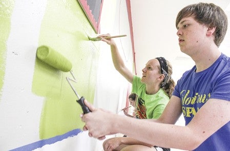 Haley Splinter and Ethan Johnson work on the AHS Cafeteria's mural Wednesday morning. The mural was designed by a company, and past and current students, and some staff, are volunteering their time to  paint it. Matt Peterson/matt.peterson@austindailyherald.com