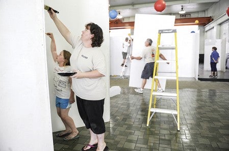 Candee Feist and her daughter Cora paint one of the painting displays as volunteers prepared the Austin downtown power plant Thursday for the Austin ArtWorks Festival this weekend.