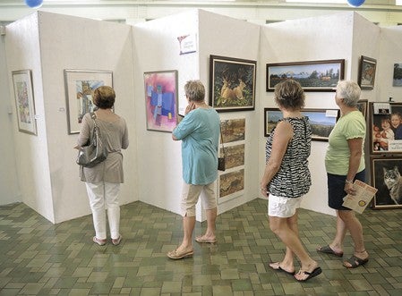 Visitors browse art displays at last year’s ArtWorks Festival. Herald file photo