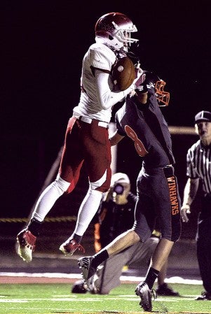 Austin receiver Zach Wessels wins a jump ball with Winona's Jared Boelter for a second-quarter touchdown in Winona Friday night. Eric Johnson/photodesk@austindailyherald.com
