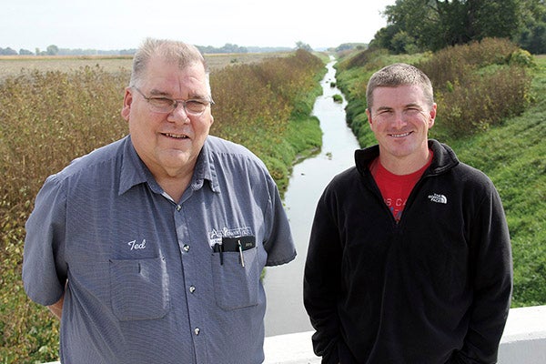 Hollandale Mayor Ted Radke, left, and Turtle Creek Watershed District Administrator Justin Hanson stand on a bridge that crosses Turtle Creek north of Hollandale. The mayor says new FEMA floodplain maps could destroy home values for half of Hollandale if they become official. Tim Engstrom/newsroom@austindailyherald.com