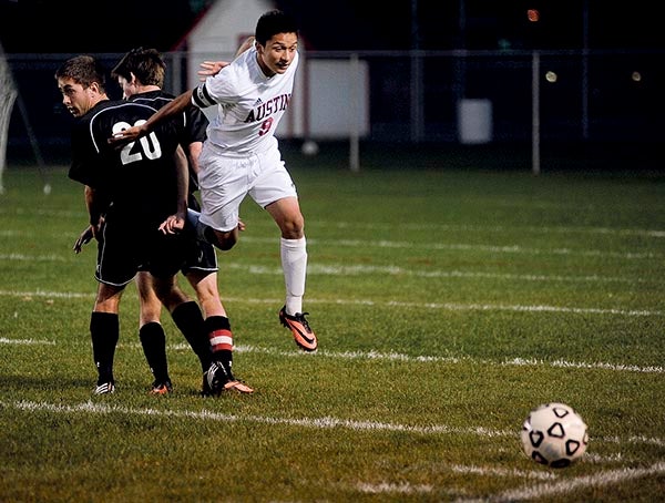 Ausitn's Franco Ortiz cuts through a pair of Rochester John Marshall defenders to get to the ball during the first half Thursday night at Art Hass Stadium. Eric Johnson/photodesk@austindailyherald.com