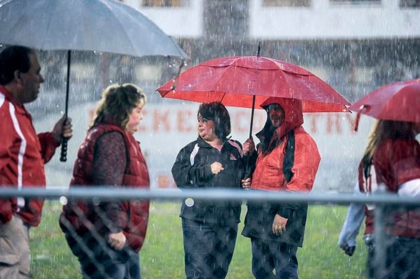 Austin Prinicipal Brad Bergstrom and wife Lisa wait in the rain as parents line up for parent's night Friday night at Art Hass Stadium. While they got the ceremony in, the game itself was postponed to Saturday night because of lightning. Look to Monday for a rundown of the game between Austin and Rochester Mayo. Eric Johnson/photodesk@austindailyherald.com