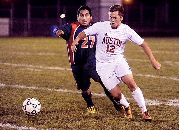 Austin's Riley Grinstead moves the ball ahead of Albert Lea's Erin Hernandez in the first half Thursday night during the team's Section 2A tournament game at Art Hass Stadium. Eric Johnson/photodesk@austindailyherald.com