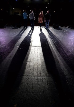 The shadows of Erin Schumacher, from left, Brian Bawek, Kaye Perry and Michael Veldman  stretches to the back of the stage at the Paramount Theatre, rehearse Thursday night for the Michael Veldman and Friends 10th anniversary show in December.
