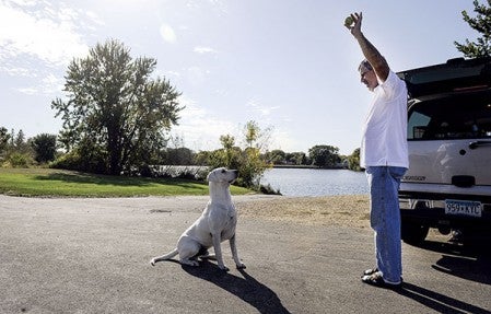 Bob Mallory gets Billy Jack to sit at East Side Lake Tuesday afternoon. Eric Johnson/photodesk@austindailyherald.com