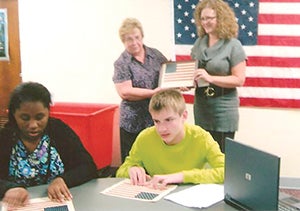Tactile USA flags are presented to students at the Minnesota State Academy for the Blind. Photo provided