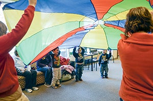 Austin’s littlest residents say hello under a parachute during the Back Packers Book Club Wednesday at the Austin Public Library. The club, a project through Austin Public Schools’ Early Childhood and Family Education program, focuses on reading and learning. -- Trey Mewes