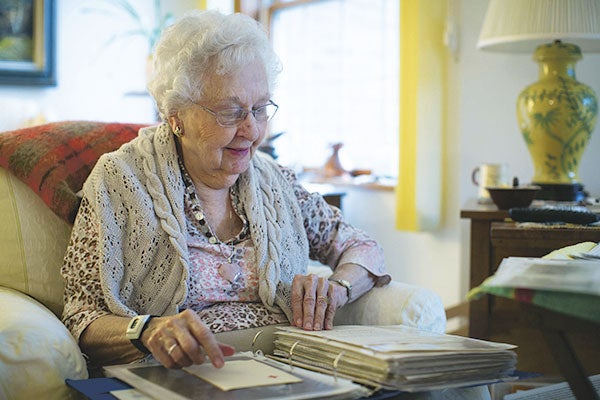 Marian Krinke, 94, at her home in Bloomington, looks through an album of photographs and other memorabilia Friday from her time as an American Red Cross volunteer in England caring for wounded World War II American soldiers. Jennifer Simonson/MPR News