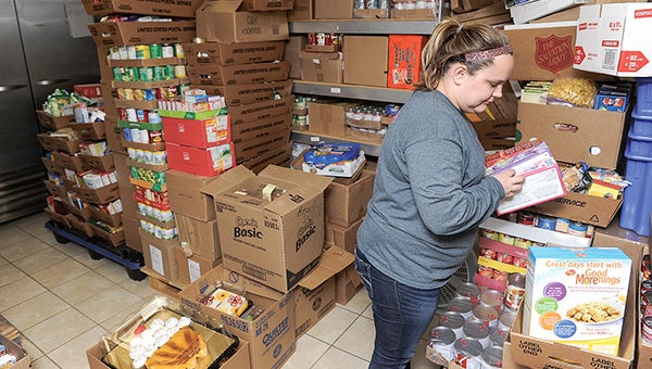 Volunteer Danielle Mork sorts and stacks food at the Salvation Army’s food shelf. -- Eric Johnson/photodesk@austindailyherald.com