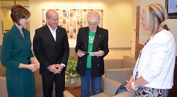 Jan Muzik, center, looks at the new Spiritually Motivated CD, “A Journey Together,” with, from left, Erin Schumacher, Michael Veldman, and Gail Dennison at The Hormel Institute Wednesday. Spiritually Motivated will donate proceeds from “A Journey Together” to The Institute’s cancer research. -- Trey Mewes