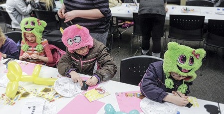 Twins Allie, left, and Madison, right, flank older sister Isabel Brekke as they work on crafts at Cornerstone Church.