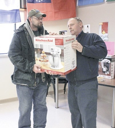 Plant Manager Claude Pulliam hands a mixer to winner and United Way donor Eric Drake at QPP Wednesday afternoon. 