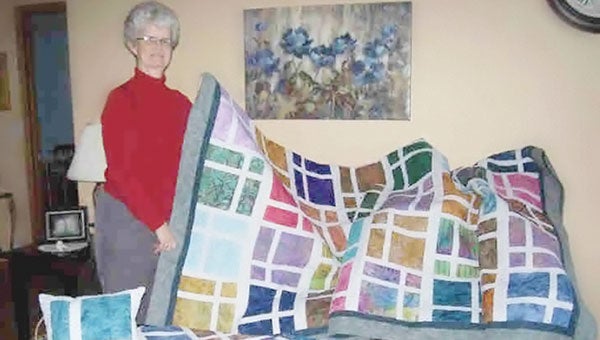 Ruth Fredrickson poses with the queen size quilt she won in a raffle. Photo provided