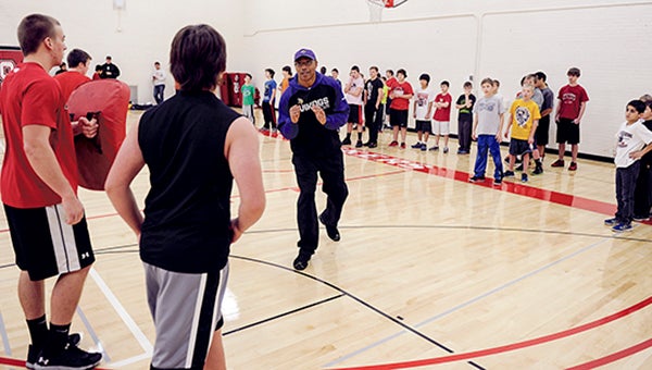 Former Minnesota Viking Carl Lee tells Sam Johnson, 13, what he did right in a drill Saturday morning during a camp put on by Lee and Chuck Foreman at Ellis Middle School. Eric Johnson/photodesk@austindailyherald.com