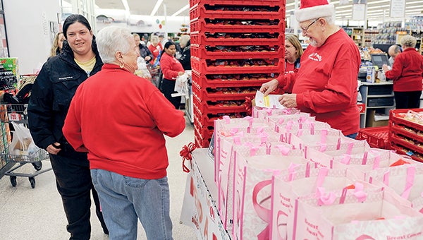 Bill and Bonnie Newell get a gift basket for a recipient during the Feed A Family Program's dispersal Friday morning at Hy-Vee. Eric Johnson/photodesk@austindailyherald.com