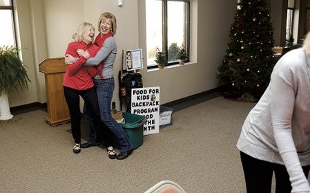 Sisters Mel Morem, left, and Kim Madson horse around while the family sets up for their annual Christmas Day community dinner at St. Olaf Lutheran Church Tuesday morning.