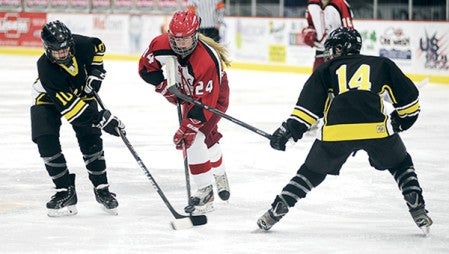 Austin's Madison Overby tries to cut the puck between Hutchinson's Allison Neubarth (10) and Jordan Guggisberg during the first period of their game in the Steve's Pizza & Austin Merchants Annual Girls Hockey Tournament at Riverside Arena Friday. Eric Johnson/photodesk@austindailyherald.com