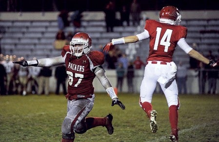 Austin's Logan Hotek begins celebrating after Ryan Snyoground's touchdown in overtime gave the Packers a 26-23 win at Art Hass Stadium. The Packers finished .500 for the first time since 2004. -- Herald file photo